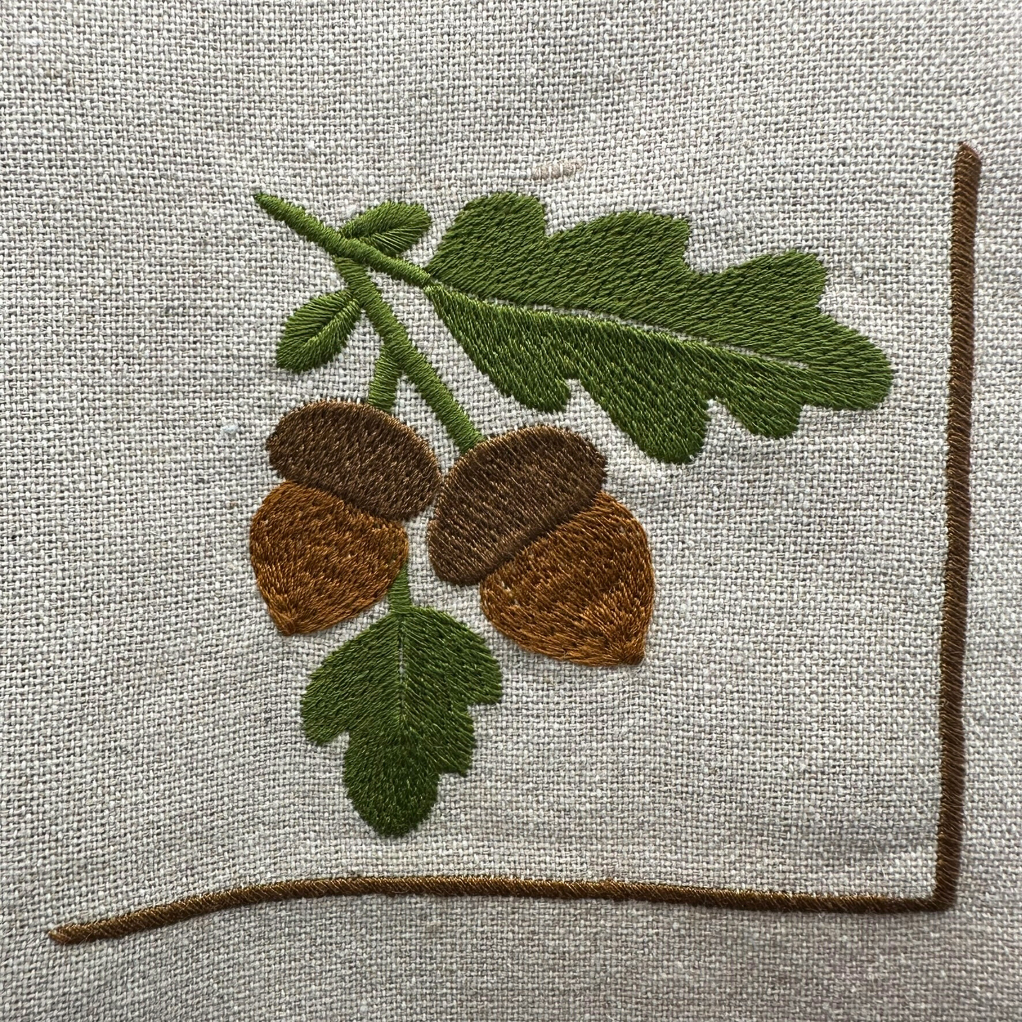 Embroidered design of acorns and leaves on napkin