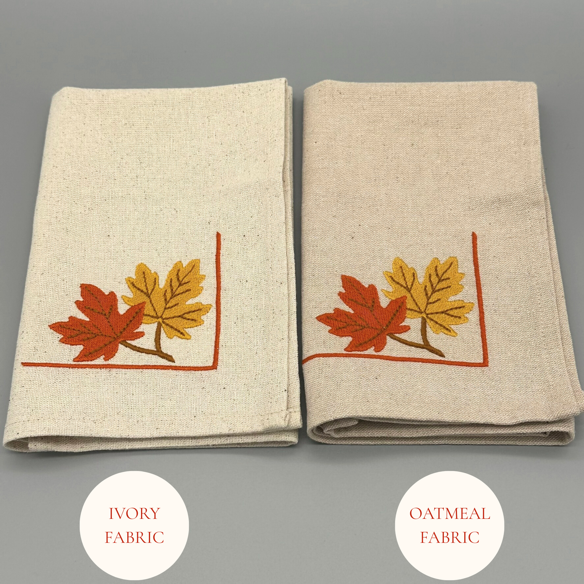 Two folded napkins with embroidered autumn leaf design