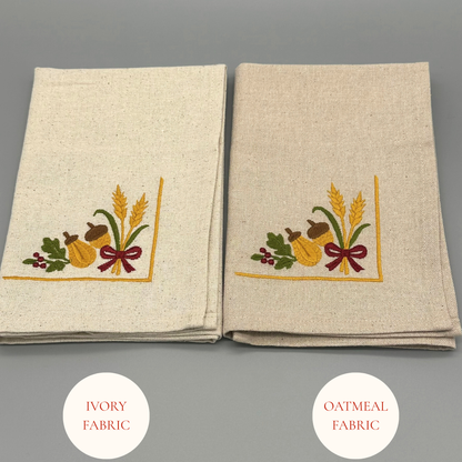 Two folded napkins with oak leaves, acorns, and wheat, and a ribbon design 