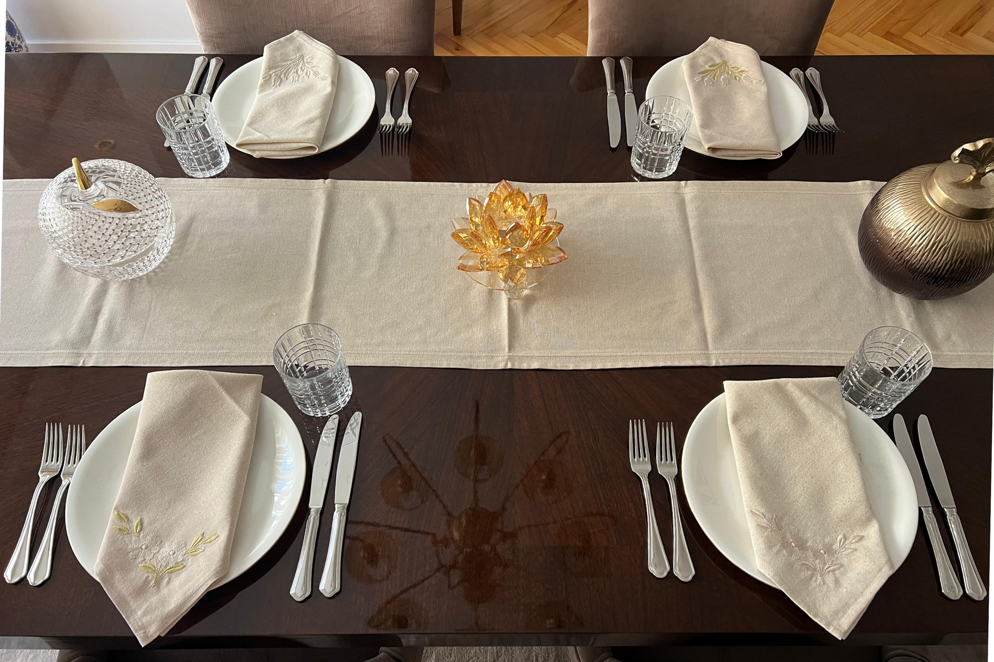 Dining table set with embroidered napkins featuring tulips and daisies. 