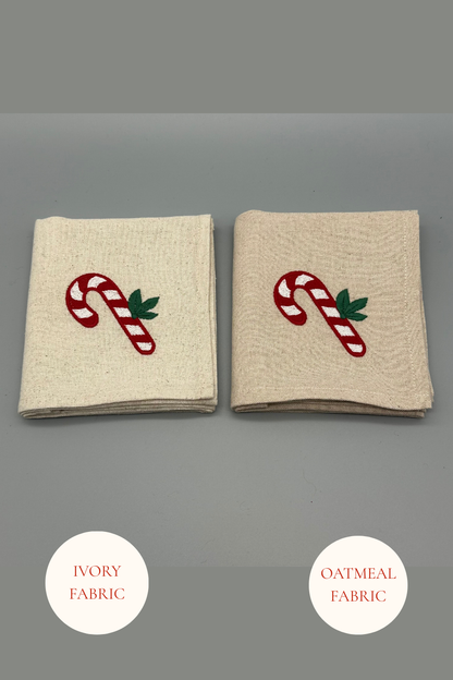 Two folded candy cane embroidered  napkins in Oatmeal and Ivory