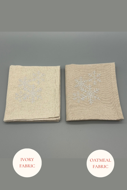 Two folded snowfall napkins in Oatmeal and Ivory