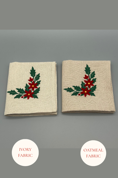 Two folded poinsettia embroidered  napkins in Oatmeal and Ivory