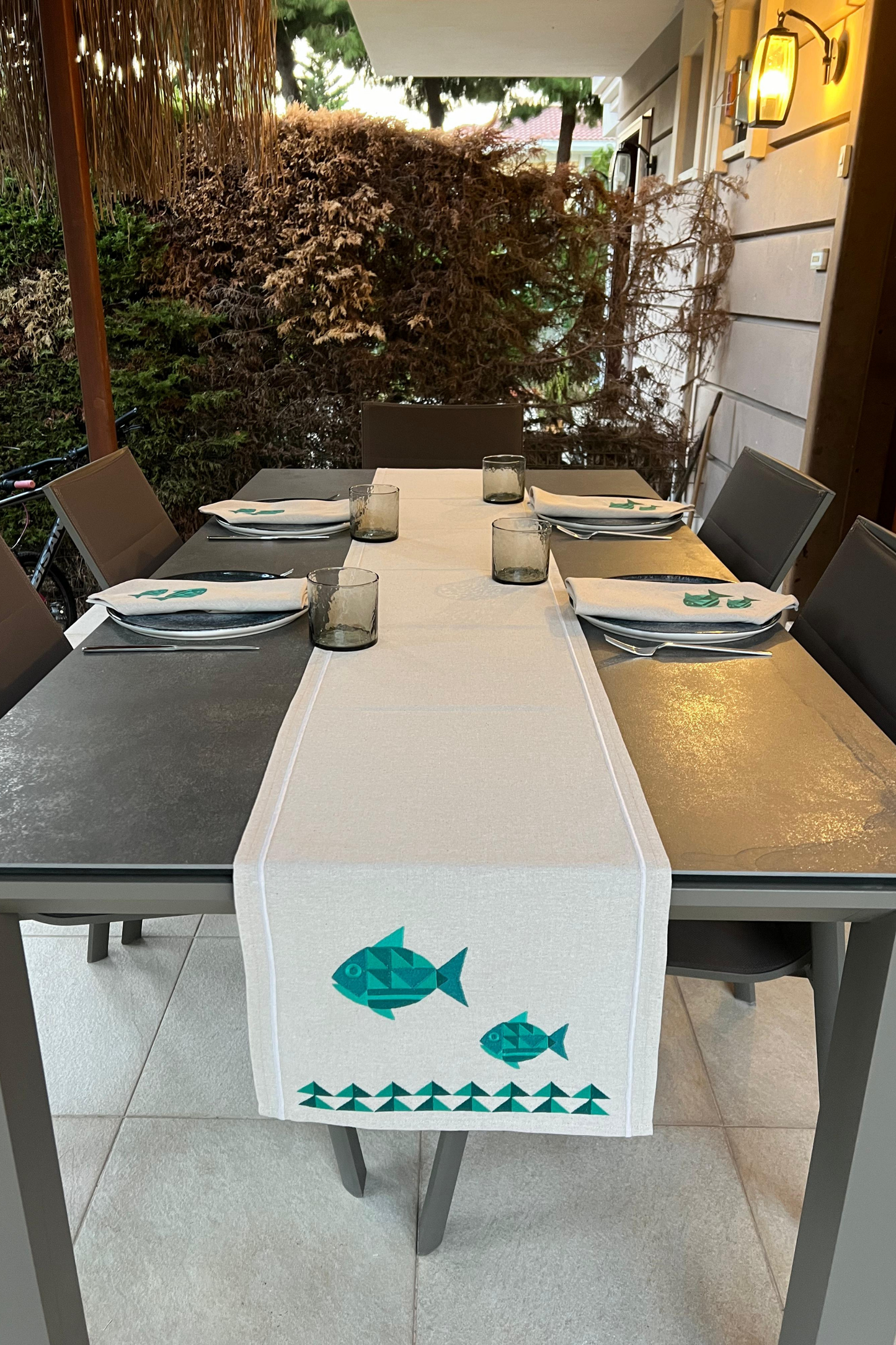 geometric fish motif embroidered napkins paired with runner on table